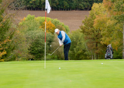 Spieler schlägt Ball in Richtung Loch